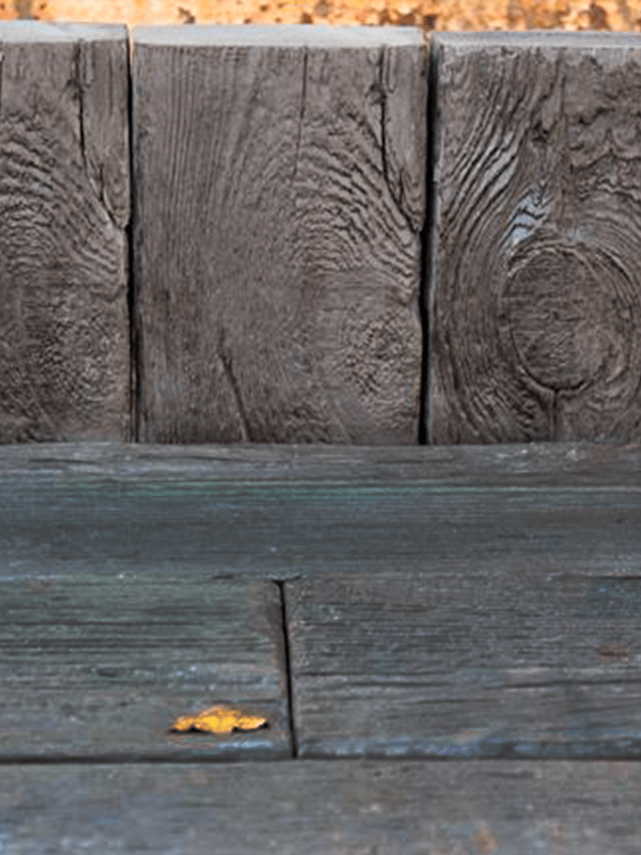 a wood surface with a leaf on it